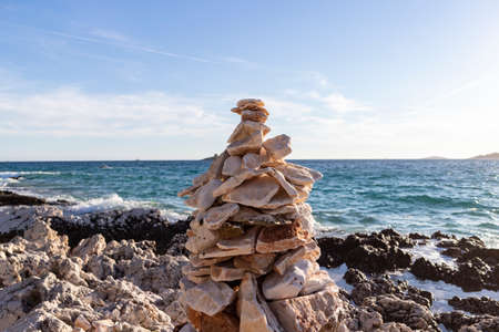Man made stone formation on the rocky beach of Rogoznica, small fishing place in central Dalmatia, Croatia, at the open sea trashing the shoreの写真素材
