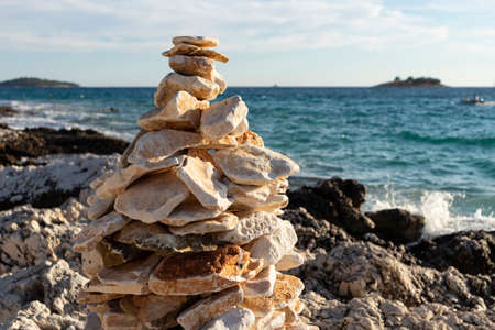 Man made stone formation on the rocky beach of Rogoznica, small fishing place in central Dalmatia, Croatia, at the open sea trashing the shoreの写真素材