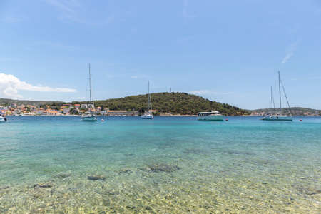 Rogoznica, Croatia-July 06th, 2021: Sailing boats anchored in the wonderful, shallow, turquoise bay of Rogoznica, Croatia, popular tourist and nautical destinationのeditorial素材