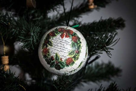 White, hand made Christmas decoration with decoupage technics hanged by the pine tree branchesの写真素材