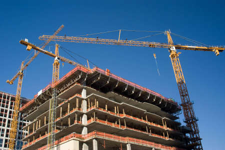 Three yellow cranes over construction site
