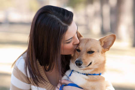 Beautiful young woman kissing her dogの写真素材