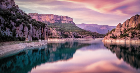 Sunset over Llosa del Cavall reservoir with mountains in background in Catalonia, Spainの写真素材