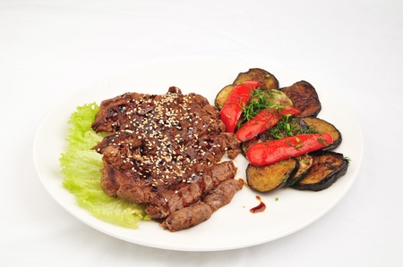 Beef baked with vegetables on a white plateの写真素材