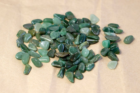 Macroshooting of natural mineral rock specimen - tumbled green aventurine gemstone on craft paper backgroundの写真素材