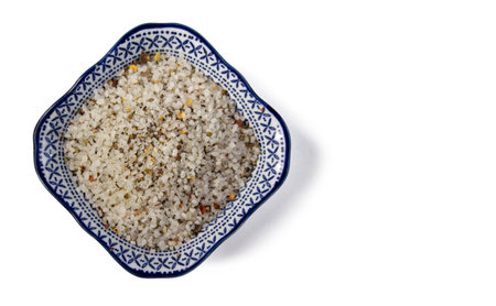Spices, white, black and red peppers, sea salt on ornamental plate on a white background, close-up, isolated top viewの写真素材