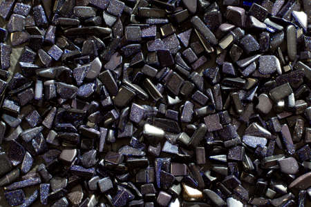 Semi-precious gemstone night cairo dark blue natural Aventurine stone on a light gray background...
