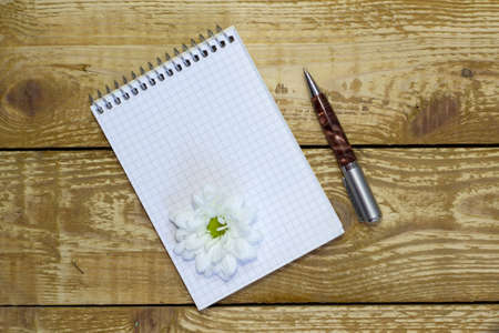 White spring notepad with blank space for writing on brown wooden textured backgroundの写真素材