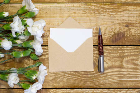 Simple small envelope with space for writing on wooden background with pen Narrow focus line, shallow depth of fieldの写真素材