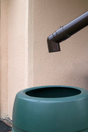 Green rainwater tank or water butt, using as rain collector to water plants in gardenの写真素材