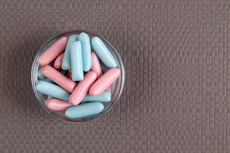 Jar full of blue and pink candies against soft gray background close upの写真素材