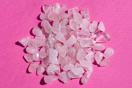 Several pieces of polished pink quartz on pink textured background. Minimal color still life photography top viewの写真素材