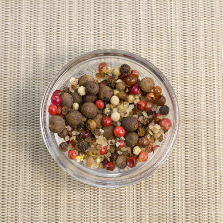 Spices, white, black and red peppers, sea salt on glass plate on gray background, close-up top view...