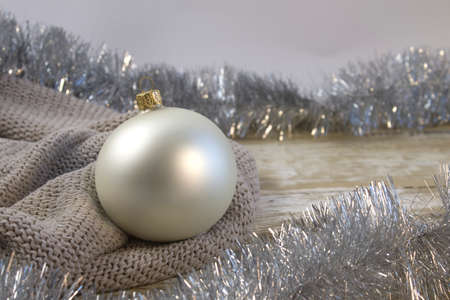 Beautiful pearl Christmas ball with patterns in a cozy light knitted background, close up close upの写真素材