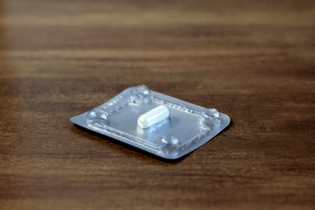 Silver blister packs of pills on dark wooden backgroundの写真素材