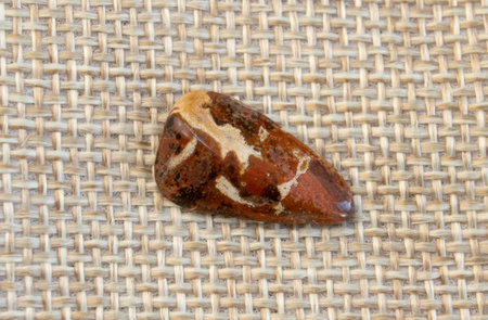 Red and multicolored jasper polished tumblestones as nice natural background top view on white plateの写真素材