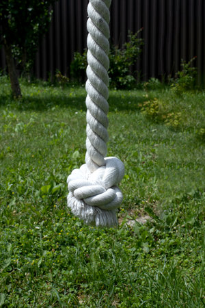 swinging knotted rope over green grass