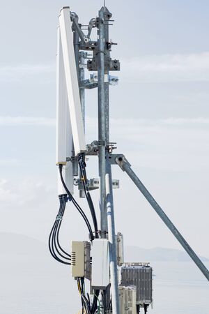 On the platform of metal pipes are antennas and cellular equipment. Foggy sky backgroundの写真素材