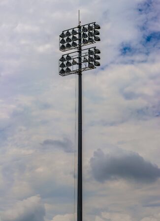 High pole with 32 floodlights to illuminate the football stadium against the sky with cloudsの写真素材
