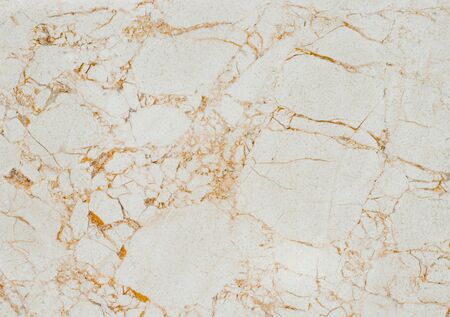 A piece of beige marble with a variety of orange cracks throughout the areaの写真素材