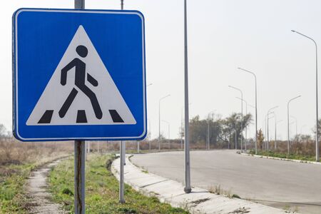 Pedestrian crossing sign near aphalized road with lanternsの写真素材