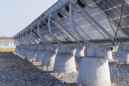 The back side of the solar panels, which is mounted on concrete supports. Sunny dayの写真素材