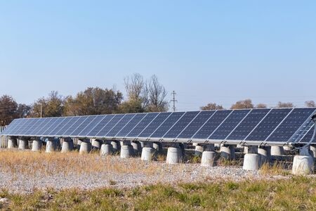 A row of blue solar panels on concrete poles. Blue sky backgroundの写真素材