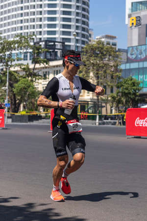 NHA TRANG, KHANH HOA PROVINCE, VIETNAM - JULY 14, 2019 Bang Trinh is a Triathlon Challenge Vietnam participant who runs a 21 kilometer stretch along Tran Phu Street near the South China Seaのeditorial素材