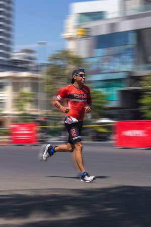 NHA TRANG, VIETNAM - JULY 14, 2019 Federico Escaler is a triathlon participant in the Challenge Vietnam event, he runs a 21 kilometer stretch along Tran phu Streetのeditorial素材