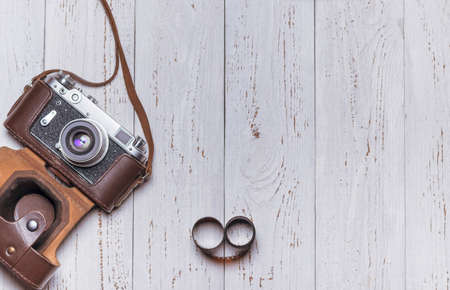 Old retro camera in a leather case and film on white boards. vintage photoの写真素材