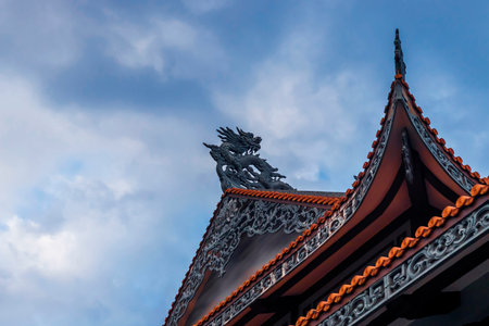 Nha Trang, Vietnam - September 23, 2019: The roof of a Buddhist temple with a dragon symbol. Against the background of the blue sky.のeditorial素材
