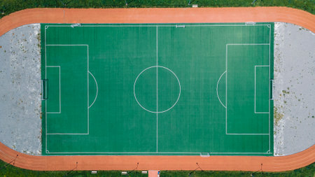 An empty soccer field with running tracks around it. view from the drone
