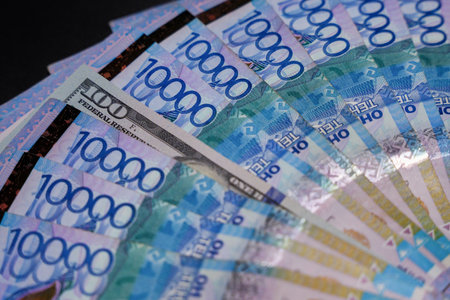100 dollars among a fan of 10,000 tenge bills. Paper money from circulationの写真素材