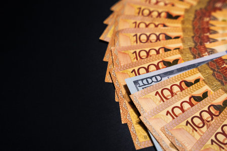100 dollars among a fan of bills of 1000 tenge. Paper money from circulationの写真素材