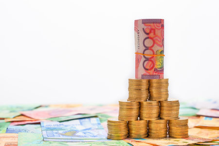 A folded 5000 tenge banknote stands on coins. Devaluation of moneyの写真素材