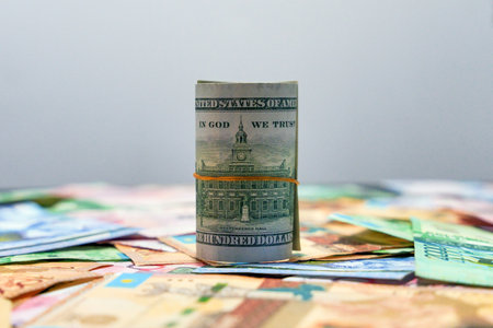 100 dollars wrapped in a rubber band with the inscription "In God we trust" on tenge bills. Currency exchangeの写真素材