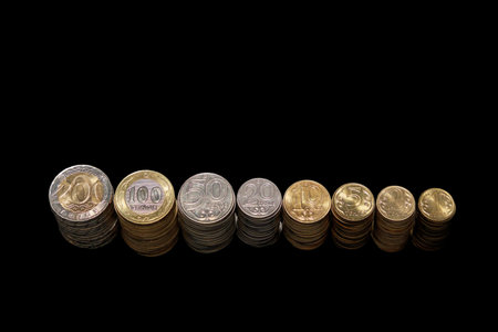 All denominations of tenge coins stand in a row. Devaluation of money. Black backgroundの写真素材