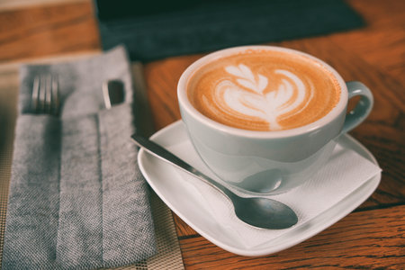 A mug of coffee on a plate with a spoon. Break timeの写真素材