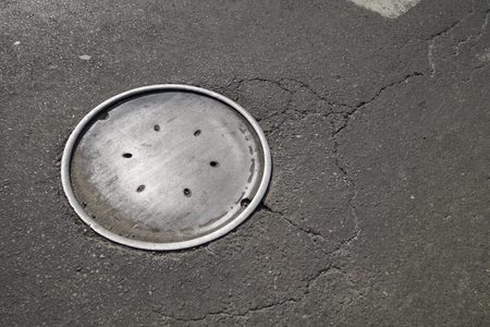 New York City Manhattan man hole cover on cracking city streetの写真素材