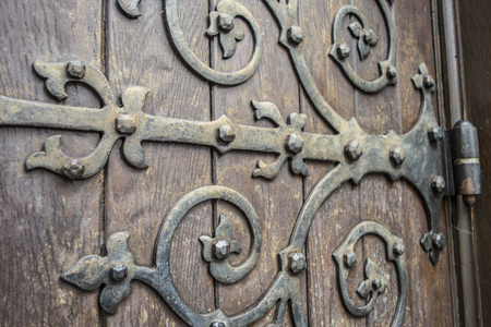 old door with hand crafted ornate iron hingeの写真素材