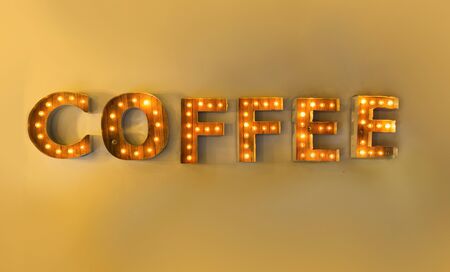 Boxed in light in the forms of letters reading the word coffee on a indoor wallの写真素材