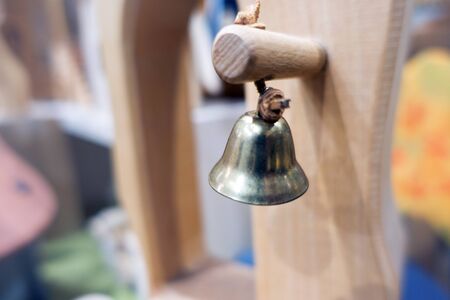 gold hanging bell on a wood toyの写真素材