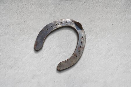 meatl horseshoe for luck and wellness on a cemete surfaceの写真素材