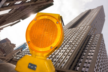 Yellow traffic light on a background of skyscrapers in New York Cityの写真素材