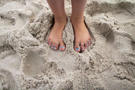 Feet in th sand of young girl on beach holiday vacation