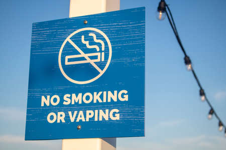 No Smoking or vaping blue square sign on a post with line of lightsの写真素材