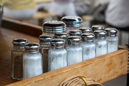 Salt and pepper shakers put aside for incoming customers at a restaurant or dinnerの写真素材