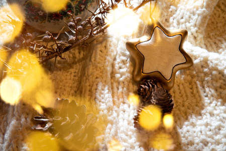 Warm Christmas atmosphere with lights, wood, pine cones and soft shadows in a colorful environment.