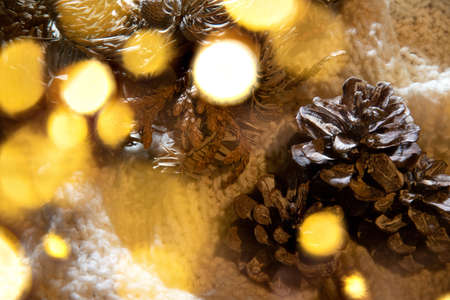 Warm Christmas atmosphere with lights, wood, pine cones and soft shadows in a colorful environment.の写真素材