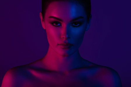 Woman on pink blue neon background. beauty. neon. make up.
